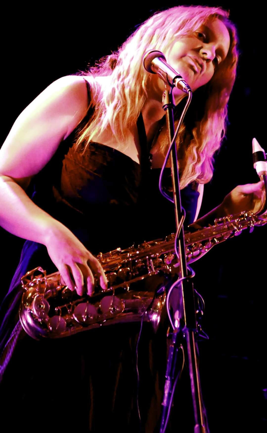 Natasha Koczy on stage with her saxophone. She offers sax lessons, singing lessons piano and music mentoring in Saltaire, near Bradford, West Yorkshire